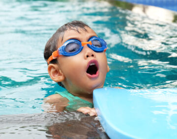 asian cute boy enjoy swimming in pool