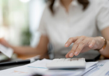 Asian female accountant or banker making calculations. Savings, finances and economy concept.