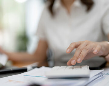 Asian female accountant or banker making calculations. Savings, finances and economy concept.