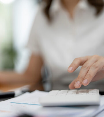 Asian female accountant or banker making calculations. Savings, finances and economy concept.